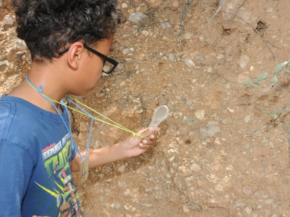 young boy inspecting dirt