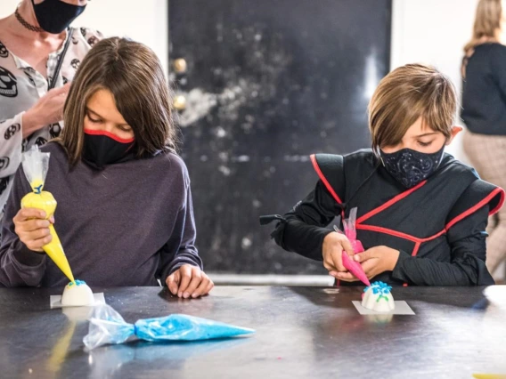 children decorating dia de los muertos items