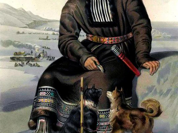 itelmen sitting on a rock with two dogs at his feet