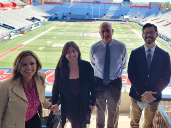 Dean Johnson group photo in front of UA Football stadium scoreboard