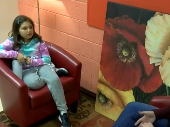 young child being interviewed by woman broadcaster