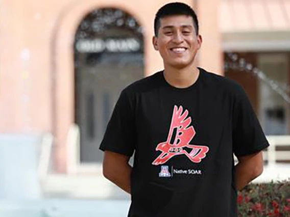 omar solis acuna standing in front of old main fountain