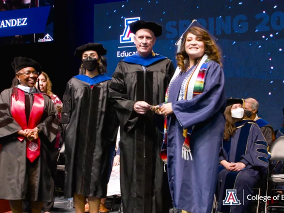 karla crespo receiving diploma on graduation stage from dean johnson