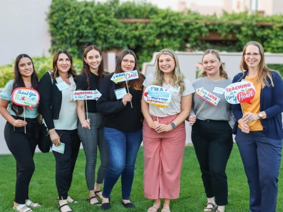 row of students holding teaching signs outdoor during az teaching fellow celebration