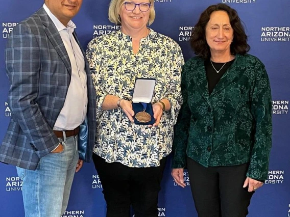 Marti Canipe standing with two other receiving her award