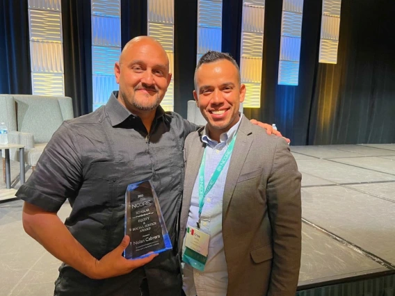 nolan cabrera standing holding his award next to another gentleman