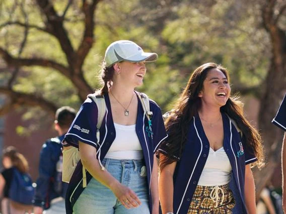 two female students walking on campus outdoors