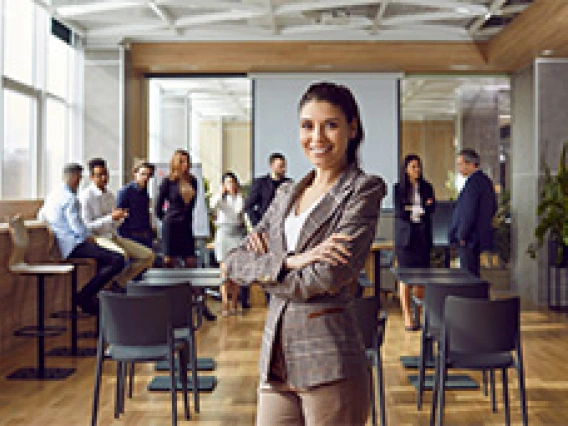 woman standing in a conference room in a brown suit