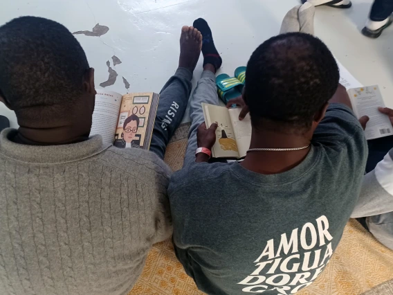 overhead view of two readers sitting on the floor with books in their hands