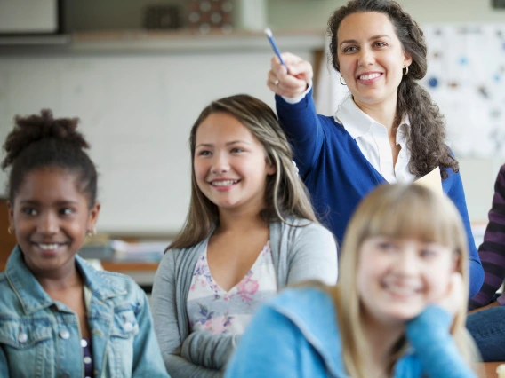 young teacher pointing a pencil, youth students around her