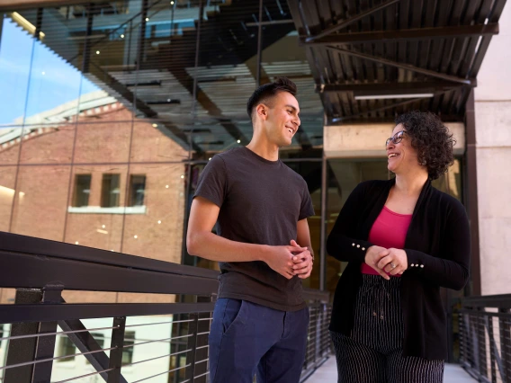 two young professionals speaking to each other in a breezeway