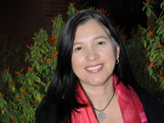 iliana reyes, medium length dark hair, gray blouse, black jacket with a red scarf