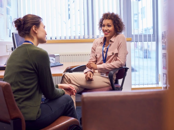 Female College Student Meeting With Campus Counselor Discussing Mental Health Issues