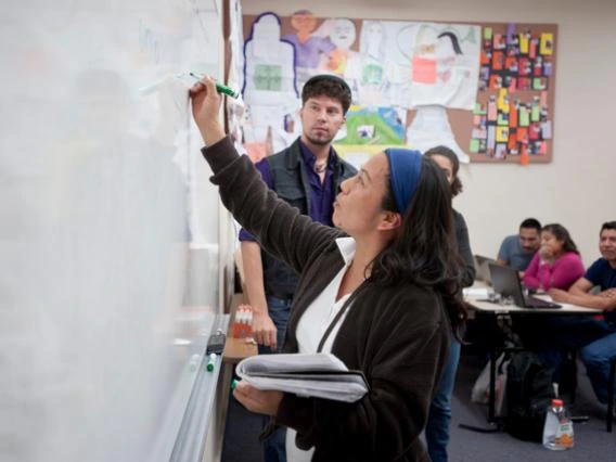 students writing on a whiteboard in a classroom setting