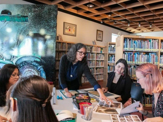 Rebecca Ballenger works with her students to prepare books for their silent books exhibit