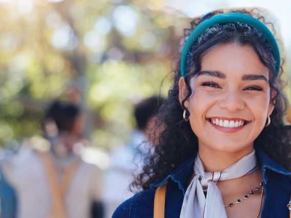 Woman, campus and student portrait with phd and smile at university ready for learning, education and class. Study, academy and happy post graduate candidate at college with backpack outdoor in park