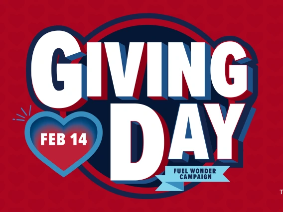 UofA Giving Day promotional graphic with bold white and blue text reading 'GIVING DAY' on a red background with subtle heart patterns. A blue heart shape with 'FEB 14' on the left, and a banner below reads 'Fuel Wonder Campaign.' The UofA logo is in the bottom right corner.