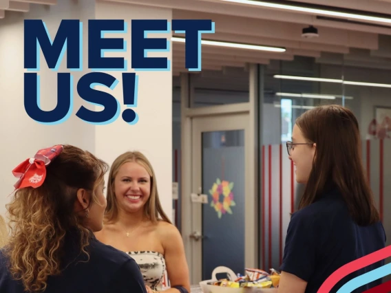 three students talking to each other, smiling and being social