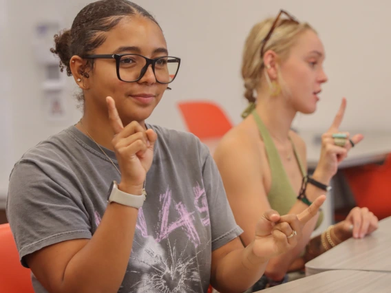 Two students learning sign language