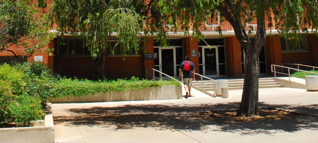 Student walking towards front entrance of the Education building