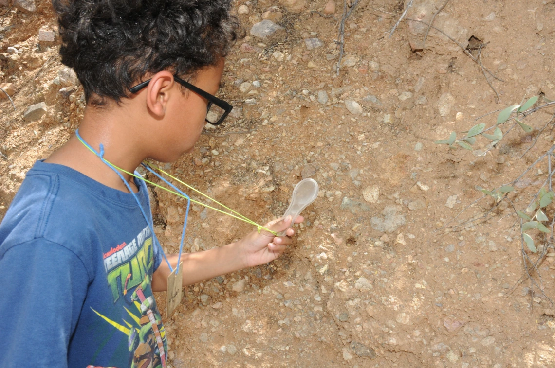 young boy inspecting dirt