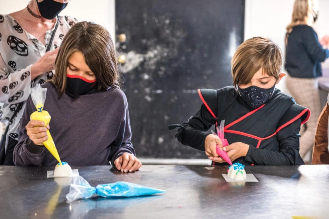 children decorating dia de los muertos items