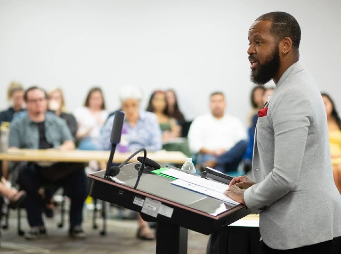 Kevin Henry lecturing from podium to a classroom full of people