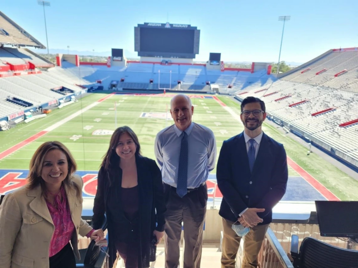 Dean Johnson group photo in front of UA Football stadium scoreboard