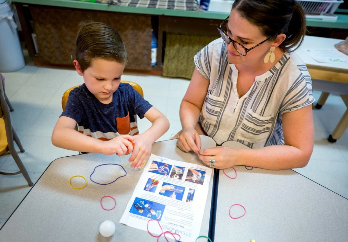 teacher and student sitting at a table