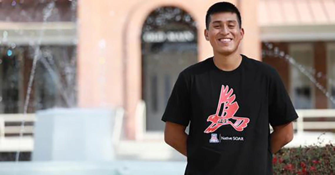 omar solis acuna standing in front of old main fountain