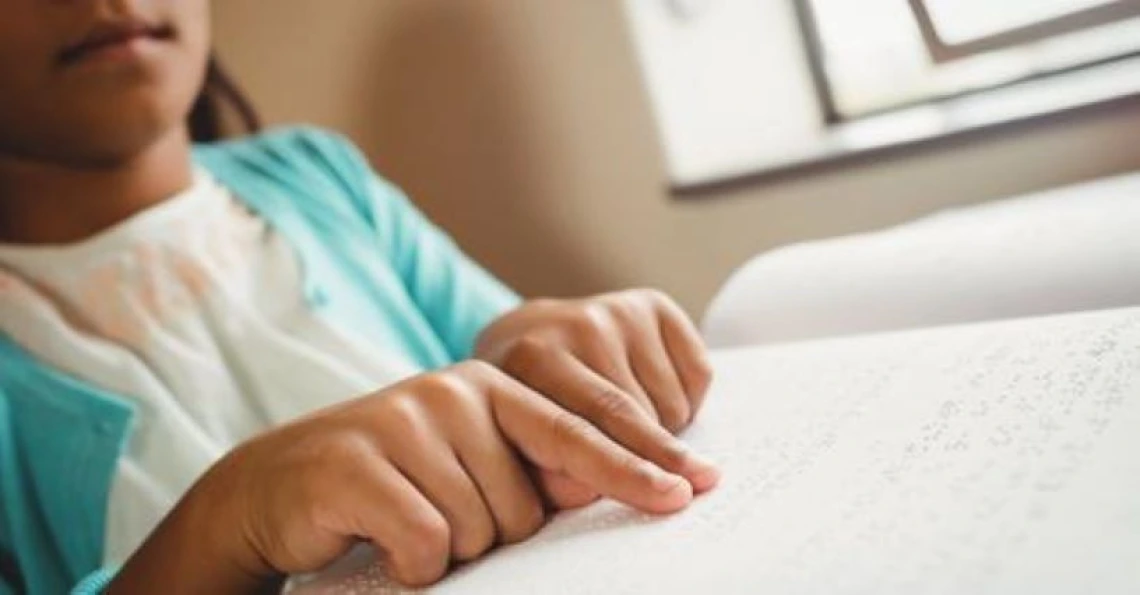 close up view of child hands reading braille