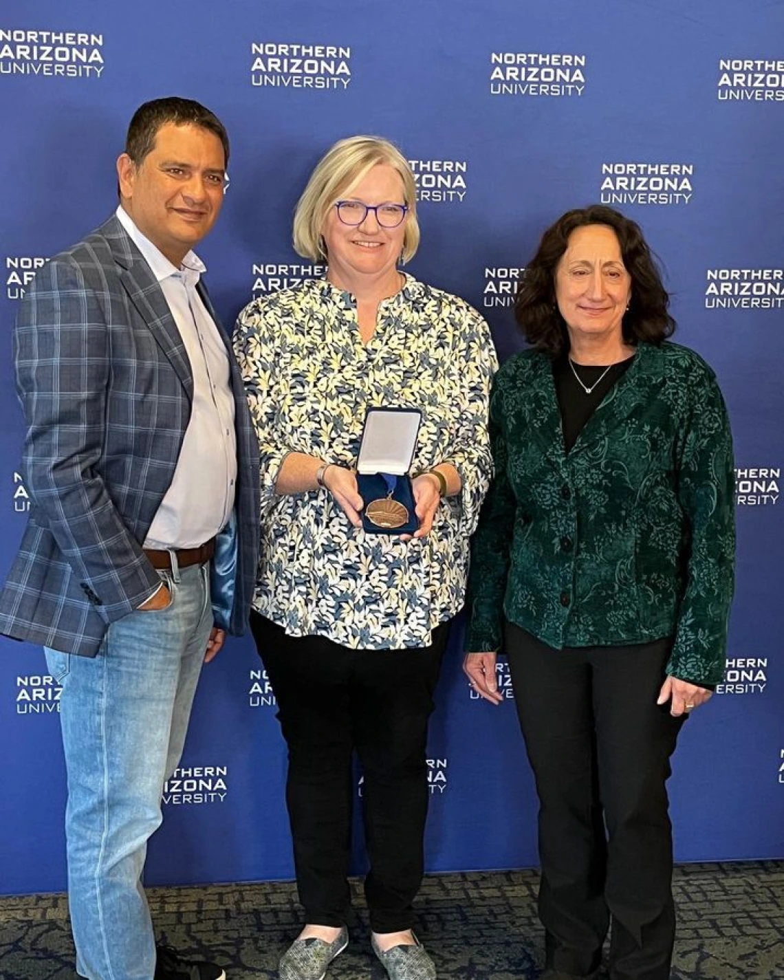 Marti Canipe standing with two other receiving her award