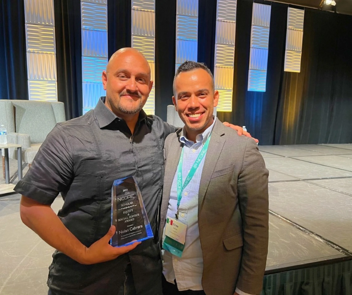 nolan cabrera standing holding his award next to another gentleman