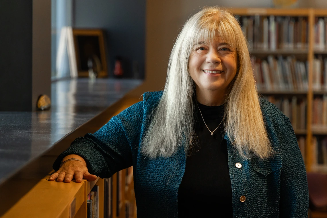 kathy short standing next to a bookcase in worlds of words