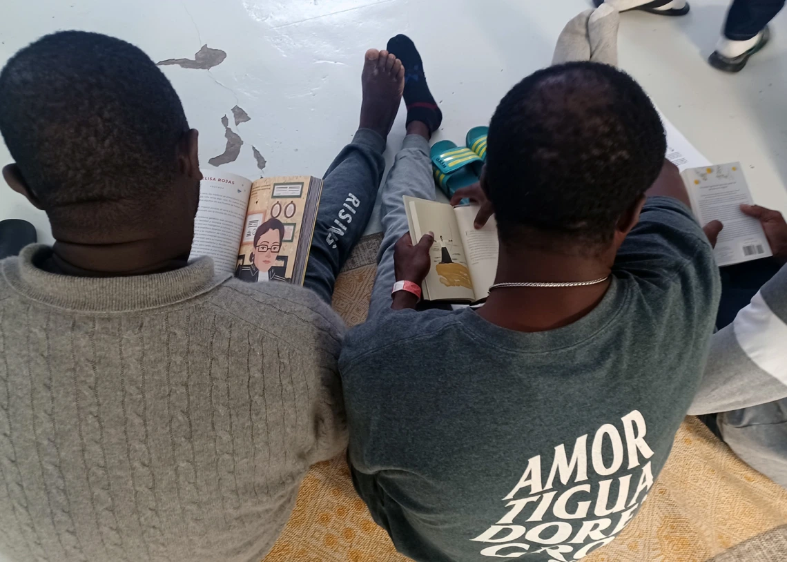 overhead view of two readers sitting on the floor with books in their hands