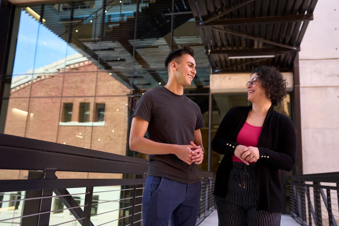 two young professionals speaking to each other in a breezeway