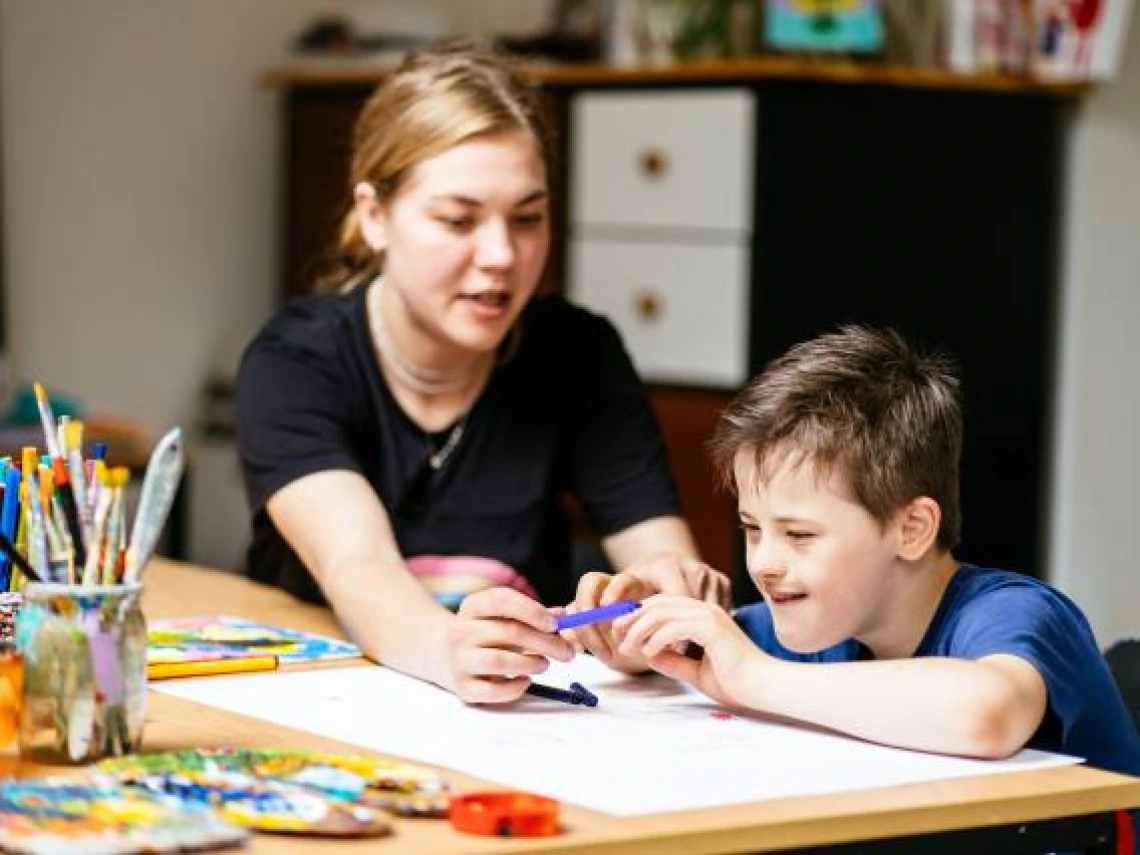 special education teacher sitting with student at a desk