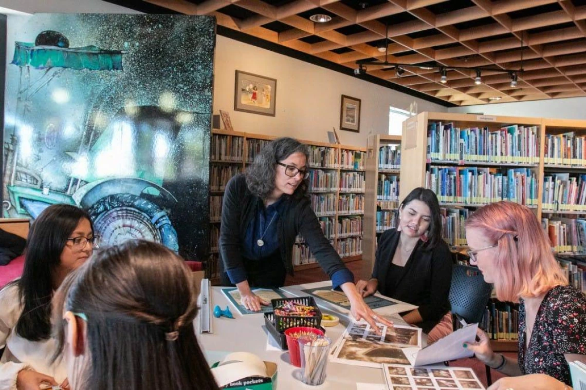 Rebecca Ballenger works with her students to prepare books for their silent books exhibit