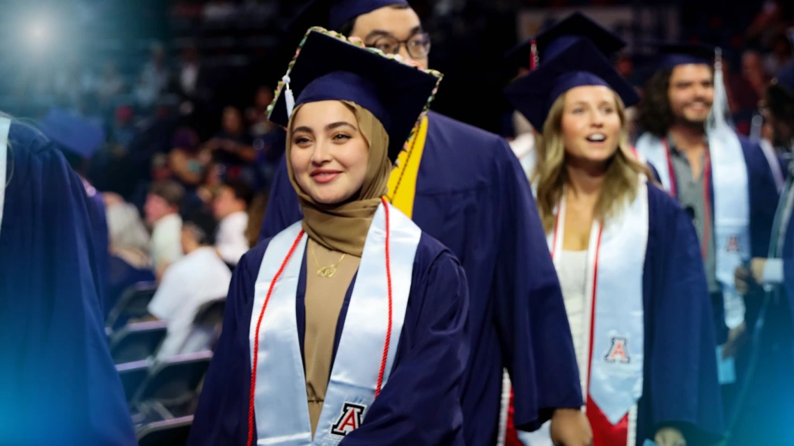 graduate in cap in gown walking during convocation