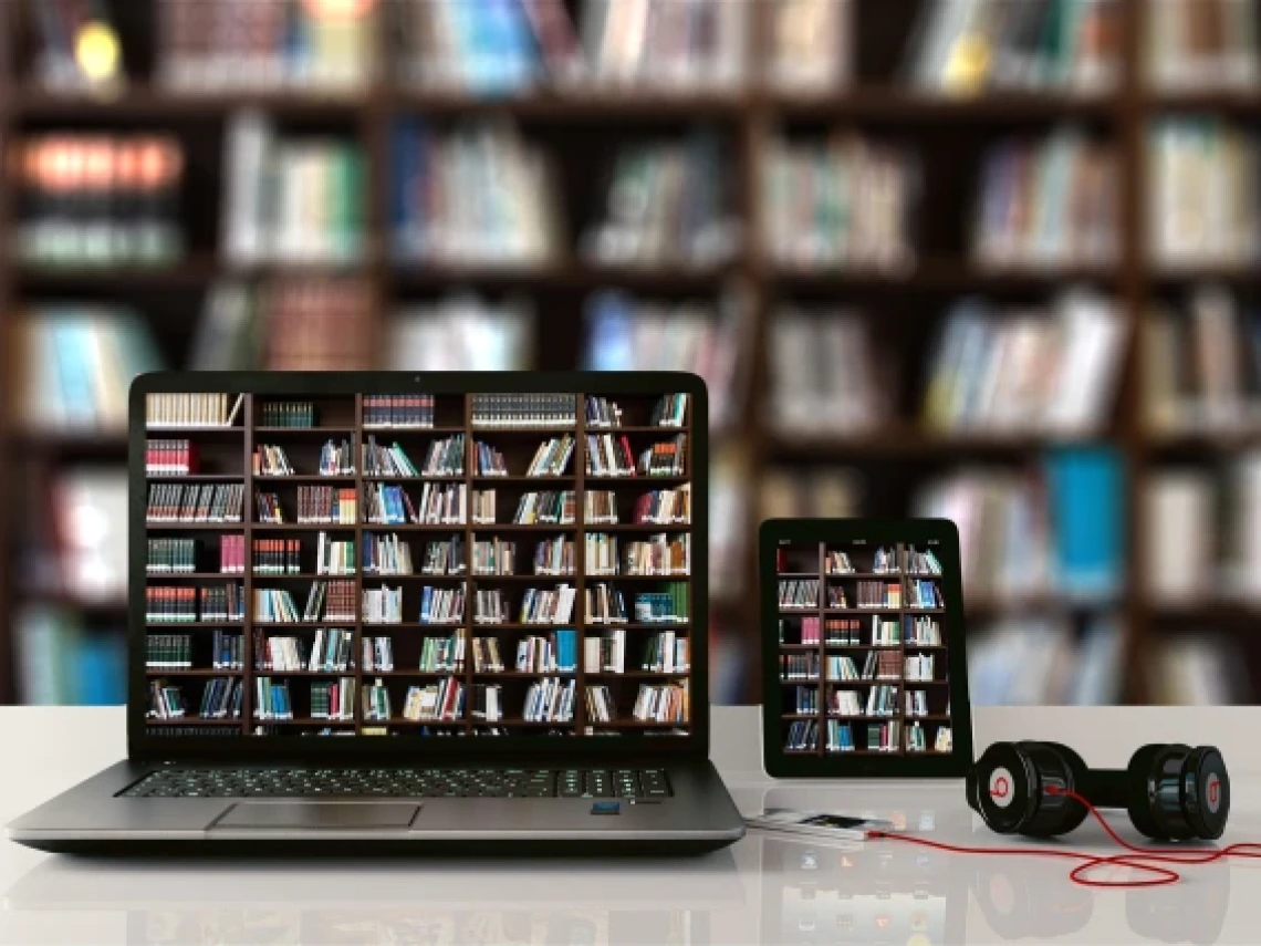 laptop and phone with bookshelves in the background