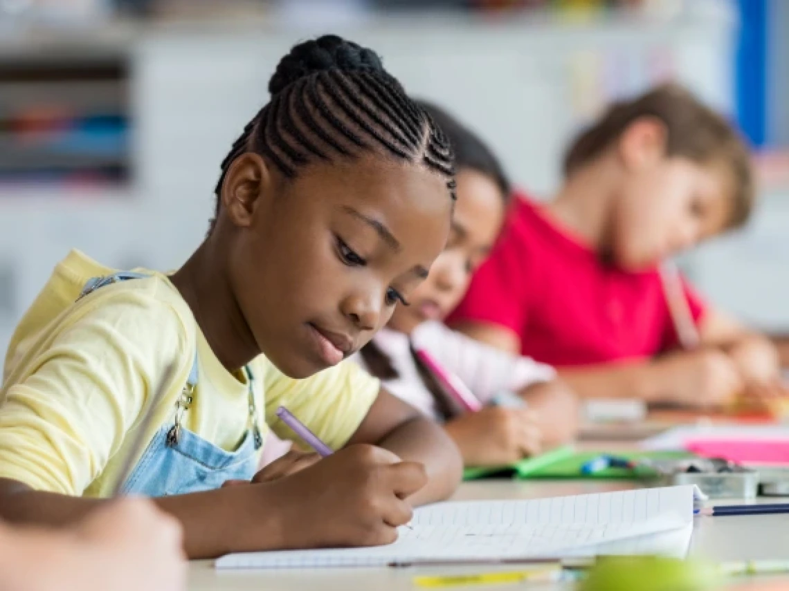 student sitting at a table and writing