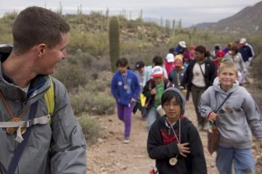 children following a leader in a school desert field trip