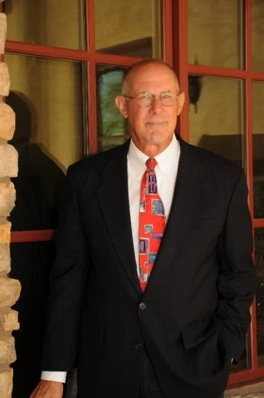 paul lindsey in a white shirt, red tie, black jacket