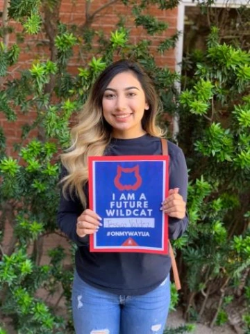 young student holding i am a future wildcat sign