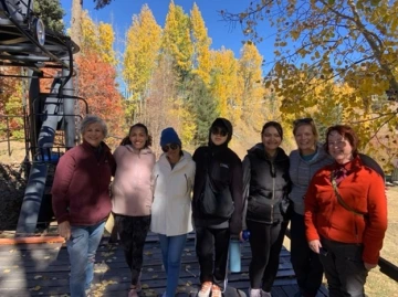 group photo under sunny sky, autumn trees in the distance
