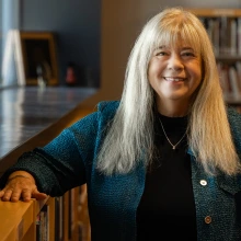 kathy short standing next to a bookcase in worlds of words