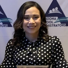 Flori Ceneno Huitt, wearing a polka dot black and white blouse, holding her award